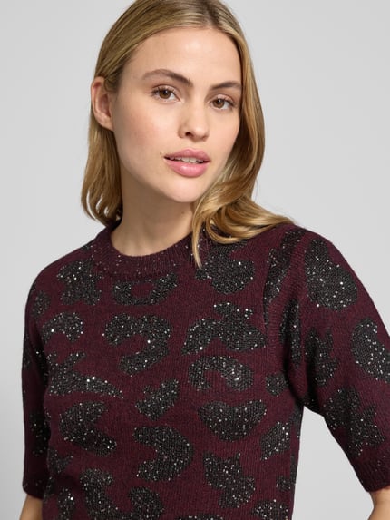 Frauenmodel trägt Shaped Fit Strickpullover mit Woll-Anteil Modell 'ZUZU 2/4 O-NECK PULLOVER' von Vero Moda, unifarben, schimmernd, abstraktes Pailetten-Muster, rundhals, 1/2-Arm, gerippte Abschlüsse, Nahaufnahme Oberkörper.