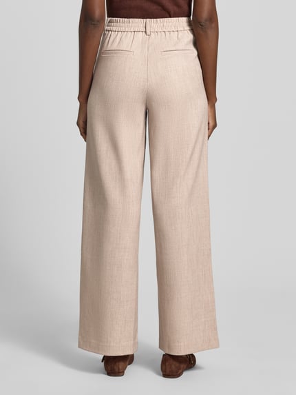 Frauenmodel trägt High Waist Hose Modell 'VARONE' von Vila in Beige, Material-Mix mit Viskose-Anteil, Wide Leg, Ganzkörperansicht Rückansicht.