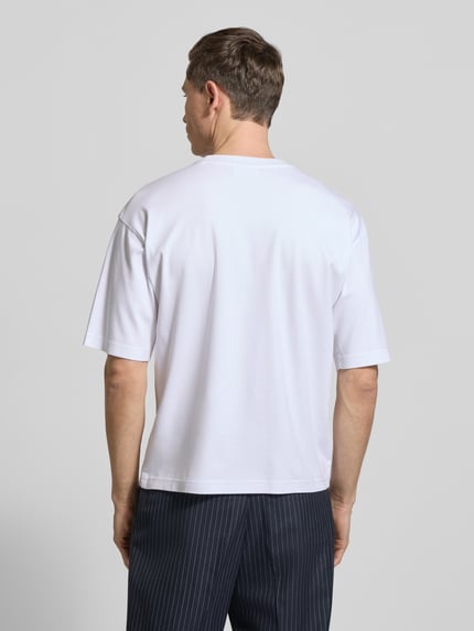 Männermodel trägt weißes Relaxed Fit T-Shirt aus reiner Bio-Baumwolle von JAKE*S STUDIO MEN, Ganzkörperansicht Rückansicht.