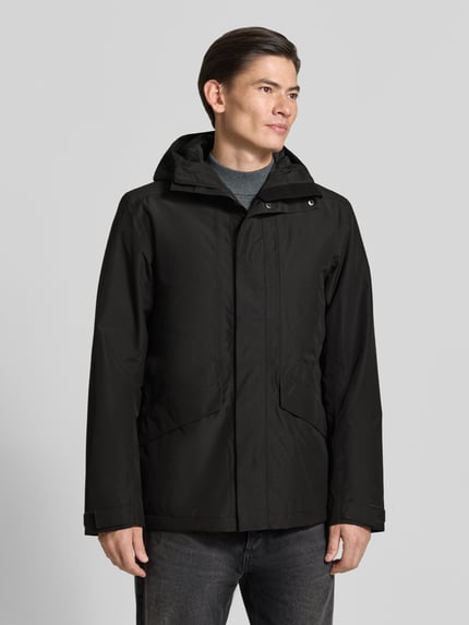 Männermodel trägt Regular Fit Jacke mit Kapuze Modell 'Adam' von Didriksons, schwarze Farbe, Eingrifftaschen, Ganzkörperansicht von vorne. Rückenlänge, Schulterbreite, Brustweite und Ärmellänge bei Größe M: 79/46/58/73 cm.