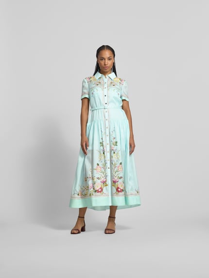 Vrouwenmodel draagt Midikleid mit Seide-Anteil van Self-Portrait, katoenmix, getailleerde pasvorm, borstzakken, riem, met korte mouwen, totale lengte maat S 134 cm, borstwijdte 46 cm, mouwlengte 20 cm, lichte blauwtinten met bloemenprint, gladde textuur. Volledige lichaamsaanzicht van voren.