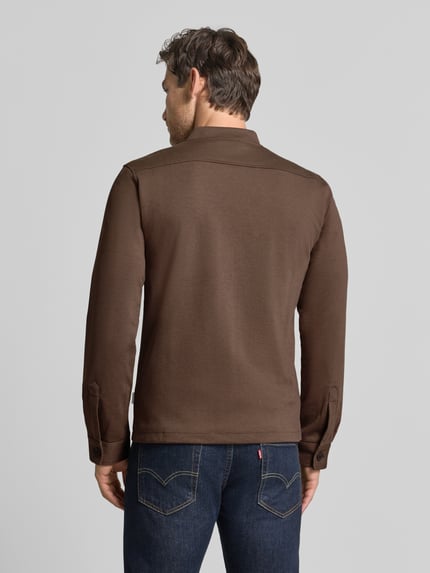 Męski model nosi Slim Fit Sweatjacke mit Stehkragen od Lindbergh, Mieszanka materiałów z dodatkiem streczu, zamek błyskawiczny, wpuszczane kieszenie, długość tyłu 67 cm, długość rękawów 66 cm, kolor brązowy, gładka tekstura. Widok całej sylwetki od tyłu.