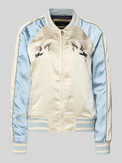 Produktfoto, Bomber Jacke mit Motiv- und Logo-Stitching von Superdry aus glänzendem Satin, hellblau und cremefarben, gerader Schnitt, Reißverschluss, elastische Bündchen, gestickte Vogelmotive, seitliche Eingrifftaschen, kurzer Stehkragen.
