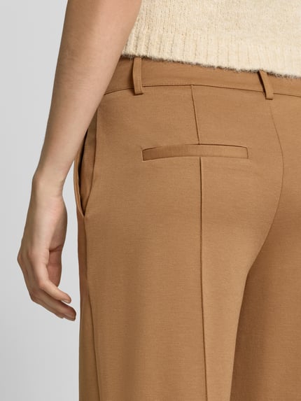 Frauenmodel trägt Wide Fit Hose mit Viskose-Anteil Modell 'Kate' von ICHI in Beige mit Ziernähten, Gesäßtaschen, Detailaufnahme.