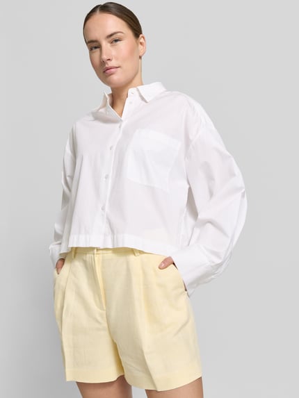 Frauenmodel trägt Shorts mit Eingrifftaschen und Gesäßleistentaschen von MICHAEL Michael Kors im Leinen-Baumwoll-Mix, Loose-Fit, Nahaufnahme Oberkörper
