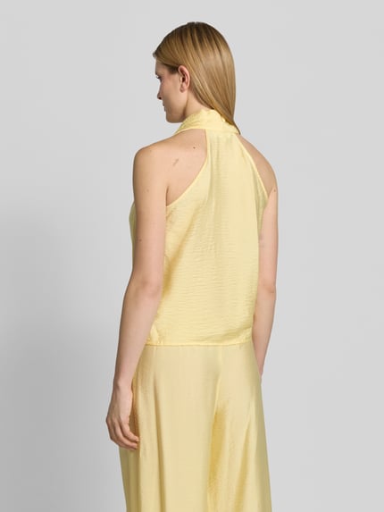 Frauenmodel trägt Regular Fit Top aus Viskose-Mix Modell 'Salma' von GUIDO MARIA KRETSCHMER WOMAN in Wickel-Optik, ärmelloses Design, Neckholder, V-Ausschnitt, Raffung, Rückenlänge bei Größe 36: 55 cm, sanft glänzender gelber Stoff, Ganzkörperansicht Rückansicht.