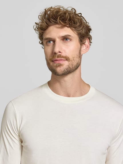 Männermodel trägt Regular Fit Longsleeve aus reiner Baumwolle Modell 'Pima' von RAGMAN, cremefarben, Nahaufnahme Oberkörper. Herren Longsleeve, Rundhalsausschnitt, Rückenlänge bei Größe M: 69 cm.
