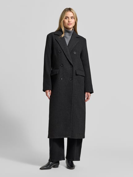 Modelka nosi Mantel aus Woll-Mix mit Reverskragen Modell 'Frannie' od My Essential Wardrobe w kolorze ciemnoszarym, krój regular fit, dwurzędowe zapięcie, kieszenie z patkami, tkanina o gładkiej fakturze, długość tyłu w rozmiarze 36: 122 cm, szerokość ramion w rozmiarze 36: 42 cm, szerokość w biuście w rozmiarze 36: 51 cm, długość rękawa w rozmiarze 36: 63 cm, widok całej sylwetki z przodu.