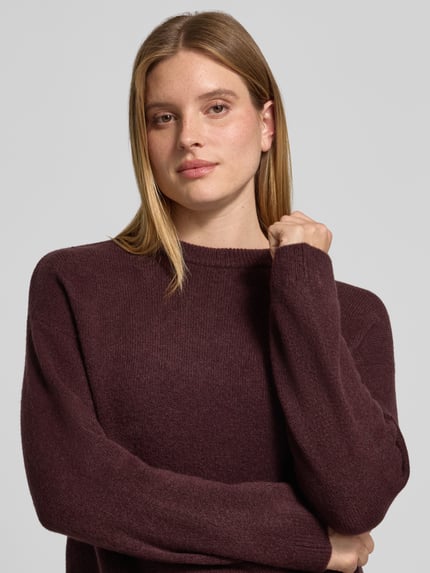 Frauenmodel trägt Pullover mit geripptem Rundhalsausschnitt von S.OLIVER CASUAL in bordeaux, strukturierte Strickoberfläche, Nahaufnahme Oberkörper.