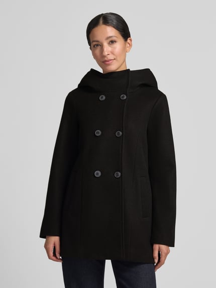 Vrouwenmodel draagt Wollmantel mit Kapuze van VERO MODA, zwart, dubbele knopen, capuchon, steekzakken, lange mouwen, afgeronde zoom, volledige vooraanzicht busteschot.