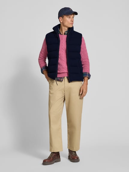 Männermodel trägt Strickjacke aus Wolle mit Stehkragen von Polo Ralph Lauren, unifarben, Struktur, Label-Detail, Ganzkörperansicht von vorne.