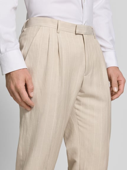 Männermodel trägt Anzughose mit Bügelfalten und Eingrifftaschen von MCNEAL in Beige mit feinem Streifenmuster, Nahaufnahme Oberkörper, Straight Fit, Haken-, Knopf- und Reißverschluss, französische Eingrifftaschen, Gesäßleistentaschen, Bundweite bei Größe 50: 37 cm, Innenbeinlänge bei Größe 50: 75 cm.
