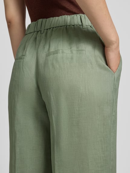 Frauenmodel trägt Regular Fit Weite Hose aus reinem Leinen von s.Oliver BLACK LABEL, Optik: Unifarben, Flammgarn, Nahaufnahme Rückenansicht.