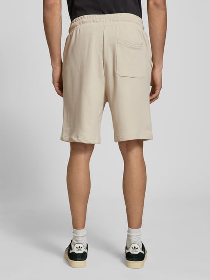 Männermodel trägt Sweatshorts mit Logo Modell 'KANE' von Jack & Jones, Beige, Baumwoll-Mix, Relaxed-Fit, Ganzkörperansicht Rückansicht.