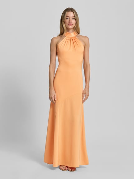 Frauenmodel trägt Neckholder-Maxikleid mit rückseitigem Reißverschluss von Lipsy in Orange, Material-Mix mit Stretch-Anteil, Figurbetont, Ganzkörperansicht von vorne. Rückenlänge bei Größe 36: 149 cm, Brustweite 41 cm.