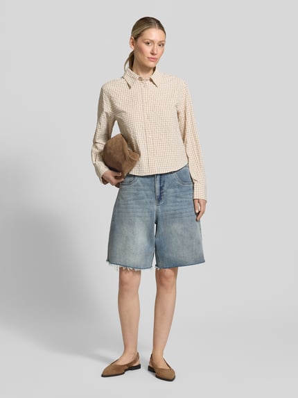 Modelka kobieca nosi Wide Leg Jeansshorts im 5-Pocket-Design od Gestuz, niebieski dżins, elastyczna bawełna, zapięcie na guzik i zamek, szerokość w rozmiarze 27: 39 cm, długość wewnętrzna nogawki: 26 cm, widok całej sylwetki z przodu.
