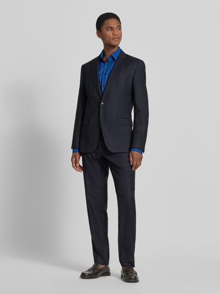 Männermodel trägt Slim Fit Business-Hemd mit Kentkragen von Jake*s in Blau aus Reine Baumwolle, Ganzkörperansicht von vorne. Rückenlänge bei Größe 39/40: 79 cm, Schulterbreite: 48 cm, Ärmellänge: 65 cm, Knopfleiste, Sportmanschetten, abgerundeter Saum.