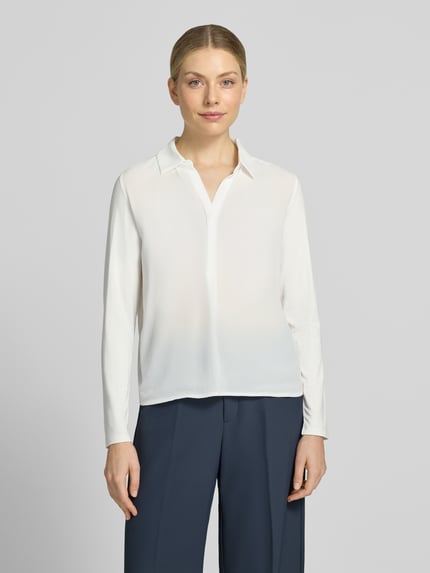 Frauenmodel trägt Regular Fit Langarmbluse mit Hemdblusenkragen Modell 'Frera' von OPUS in Weiß, glatte Struktur, Ganzkörperansicht von vorne. Damen Langarmbluse von OPUS.