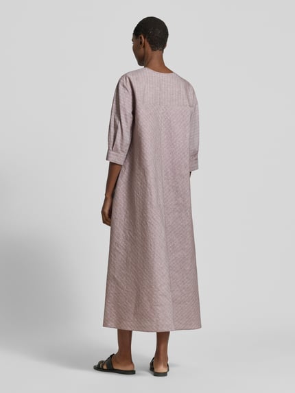 Vrouwenmodel draagt midi-jurk uit mix van linnen en katoen met 3/4-mouw, wide fit, model 'MEMO' van MM by Max Mara, ruglengte 126 cm, borstwijdte 50 cm, mouwlengte 40 cm, druppelvormige hals met striksluiting, licht gemêleerde structuur, kleur lichtpaars, model MEMO, geheelbeeld achteraan.