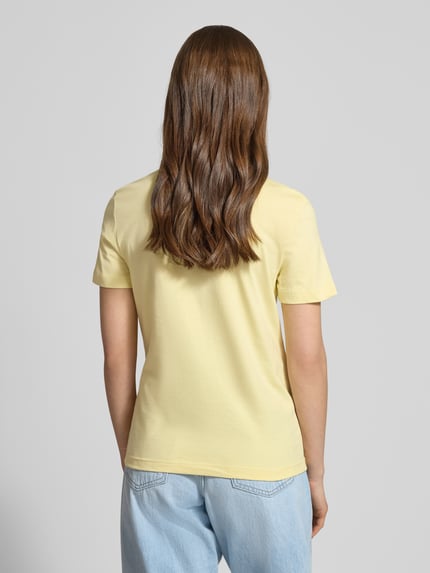 Kobiece modelka nosi T-Shirt mit Rundhalsausschnitt und Label-Stitching od Calvin Klein Jeans, czysta bawełna, krój regular fit, długość tyłu w rozmiarze S: 52 cm, jasny żółty kolor, prosta forma, gładka tekstura, widok całej sylwetki od tyłu
