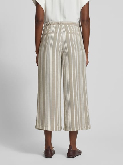 Vrouwenmodel draagt Culotte met Kordelzug und Eingrifftaschen van Christian Berg Woman, loose fit, elastische tailleband met koord, Franse steekzakken, decoratieve achterzakken, beige-witte strepen, textuur van licht stof, Ganzkörperansicht Rückansicht.