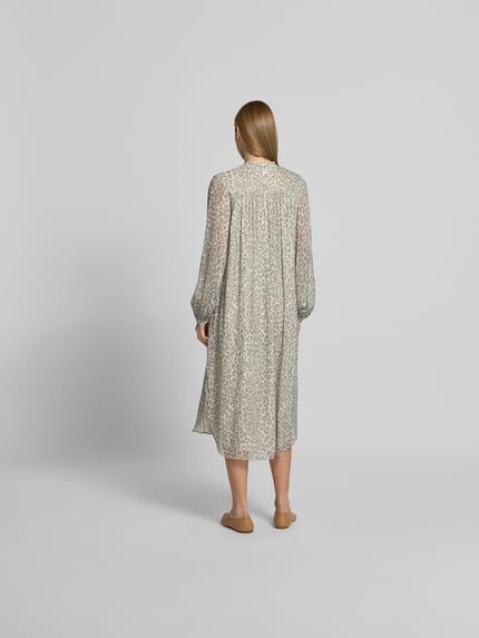 Frauenmodel trägt Midikleid mit Allover-Animal-Print von Lala Berlin in Beige-Braun, semitransparent, reine Viskose, Ganzkörperansicht Rückansicht.