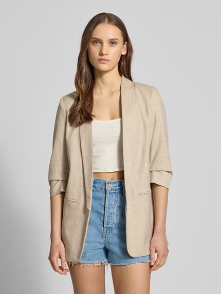 Modelka nosi Regular Fit Longblazer mit 3/4-Ärmeln Modell 'ELLY' von Only, kolor melanż, szalowy kołnierz, bez zapięcia, imitowane kieszenie, widok całej sylwetki z przodu.