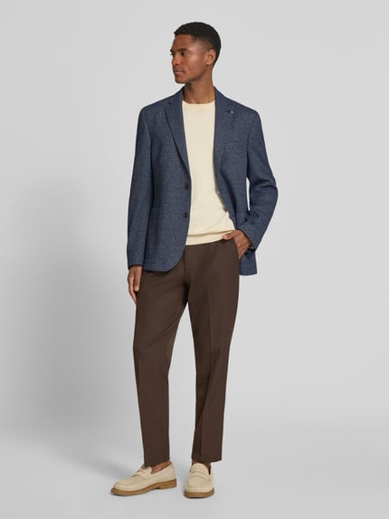 Männermodel trägt Slim Fit 2-Knopf-Sakko mit Strukturmuster von bugatti, blau, Reverskragen, Ganzkörperansicht von vorne.