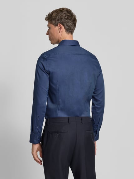 Männermodel trägt Slim Fit Businesshemd mit Kentkragen von Seidensticker, dunkelblau, strukturierte Webware, Ganzkörperansicht Rückansicht.