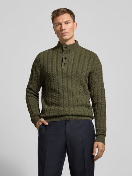Männermodel trägt Strickpullover mit gerippten Abschlüssen von Fynch-Hatton, Baumwoll-Woll-Mix, Regular-Fit, Stehkragen, Knopfleiste, Ganzkörperansicht von vorne.
