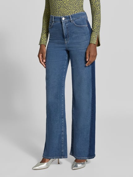 Frauenmodel trägt Wide Leg Jeans mit Eingrifftaschen von Marc Cain, Baumwoll-Mix mit Lyocell-Anteil, mittlere Blautöne, Kontraststreifen, Ganzkörperansicht von vorne.