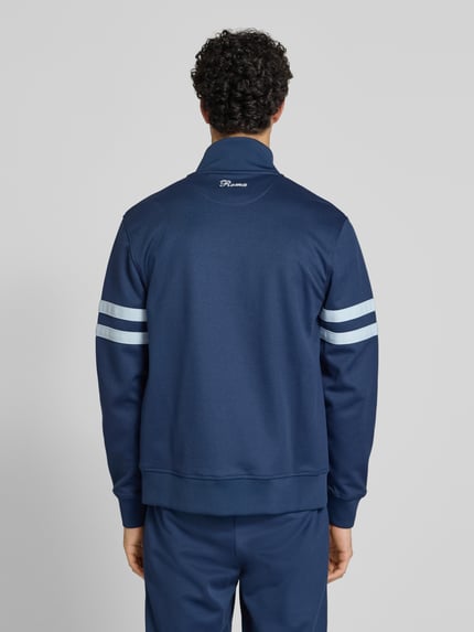 Männermodel trägt Sweatjacke aus Baumwoll-Mix Modell 'ROMA' von Ellesse in Dunkelblau mit weißen Streifen, Gerade Passform, Rückenansicht.
