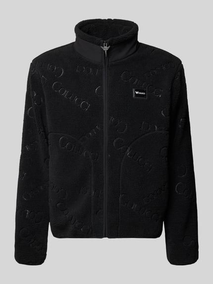 Produktfoto, schwarze Regular Fit Teddyjacke mit Label-Patch von COLUCCI, Teddyfell-Oberfläche, Stehkragen, Reißverschluss, seitliche Eingrifftaschen, Maße bei Größe M: Rückenlänge 70 cm, Schulterbreite 49 cm, Brustweite 60 cm, Ärmellänge 67 cm