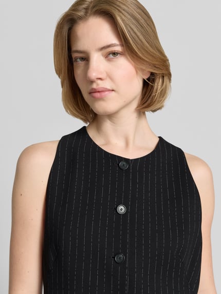 Frauenmodel trägt Slim Fit Weste aus reiner Viskose Modell 'JULERAN' von BOSS, Nadelstreifen, Label-Applikation, Nahaufnahme Oberkörper.