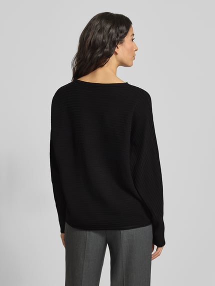 Frauenmodel trägt schwarzen Relaxed Fit Pullover aus Viskose-Mix von s.Oliver RED LABEL, Optik: Unifarben, Rippstrick, Ganzkörperansicht Rückansicht.