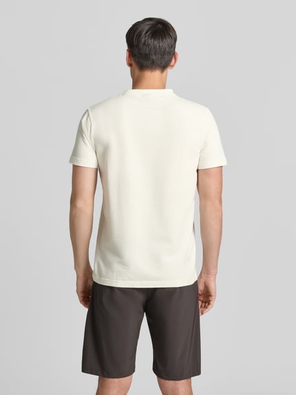 Männermodel draagt T-shirt met structuurpatroon en gestikt logo van Lerros, katoenmix met stretch, regular fit, ruglengte maat M 75 cm, ganzkörperansicht rückansicht.