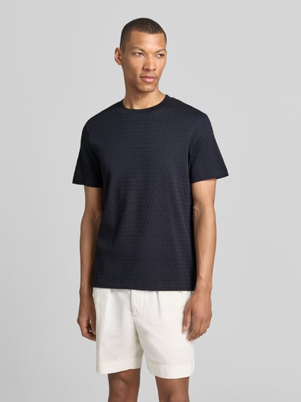Männermodel trägt T-Shirt mit Strukturmuster Modell 'Raulos' von JOOP! Collection aus Reine Baumwolle, Modern Fit, Nahaufnahme Oberkörper.