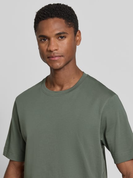 Männermodel trägt Slim Fit Poloshirt mit V-Ausschnitt Modell 'Braian' von Drykorn aus Reine Baumwolle mit Strukturmuster, Nahaufnahme Oberkörper. Rückenlänge bei Größe M: 70 cm.