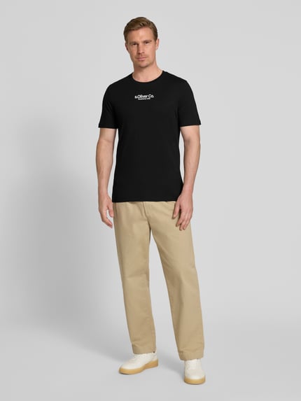 Männermodel trägt Regular Fit T-Shirt aus reiner Baumwolle von s.Oliver RED LABEL, Optik: Unifarben, Label-Schriftzug, Rundhals, Kurzarm, Materialverarbeitung: Jersey, Ganzkörperansicht von vorne.