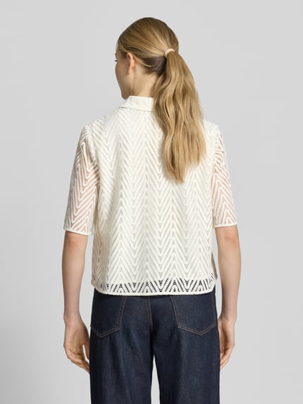 Frauenmodel trägt Regular Fit Hemdbluse in Spitzen-Optik von Comma, cremefarben, semitransparent, Halbarm, Ganzkörperansicht Rückansicht.