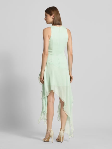 Frauenmodel trägt Cocktailkleid mit asymmetrischem Rock Modell 'IVANA' von Bardot aus mintfarbenem Chiffon mit floralen Applikationen, Taillierter Schnitt, Minikleid, Rückseitiger Haken- und Reißverschluss, Ganzkörperansicht Rückansicht.