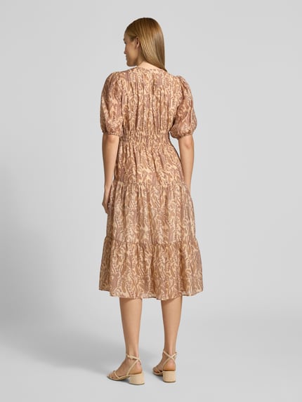 Frauenmodel trägt Midikleid aus Lyocell-Mix Modell 'Tanyssa' von Bash mit Paisley-Print in Beige, tailliert, Rückenansicht, Ganzkörperansicht.