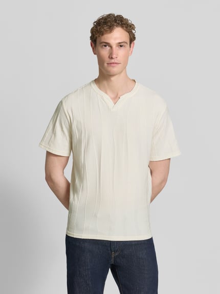 Männermodel trägt T-Shirt mit Strukturmuster und V-Ausschnitt von Antony Morato in Creme, Baumwoll-Mix, Regular Fit, Ganzkörperansicht von vorne.