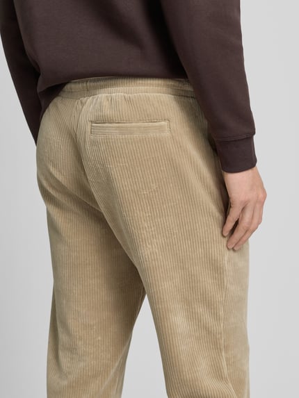 Männermodel trägt Sweatpants mit elastischem Bund von MCNEAL aus beigem Baumwoll-Mix mit Stretch-Anteil, Gerader-Schnitt, Gesäßtasche, Detailaufnahme Rückansicht.