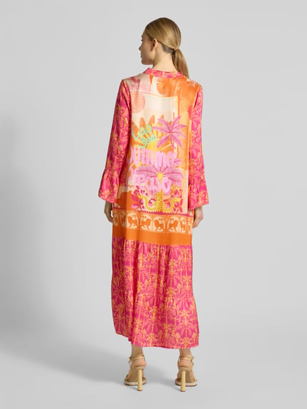 Frauenmodel trägt Midikleid aus Reine Viskose mit A-Linie und Allover-Look, Modell 'Orange Palm' von miss goodlife, Ganzkörperansicht Rückansicht.