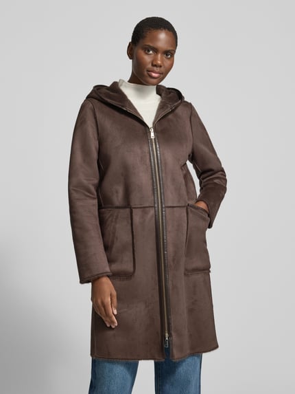 Frauenmodel trägt einen unifarbenen Teddymantel mit Kapuze von CH. BERG WOM. SELECTION, braune Struktur, Longline, Teilungsnähte, Reißverschluss, aufgesetzte Seitentaschen, Langarm, geschlitzter Saum, Ganzkörperansicht von vorne.