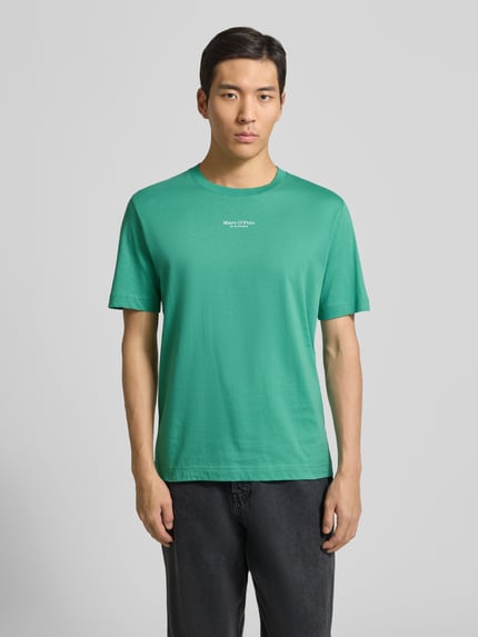 Męski model nosi Regular Fit T-Shirt aus reiner Baumwolle od Marc O'Polo, efekt: jednolity kolor, nadruk z logo, okrągły dekolt, krótki rękaw, dżersej, czysta bawełna, całkowity widok z przodu.