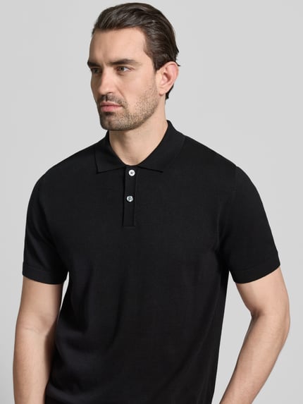 Männermodel trägt Regular Fit Poloshirt in tricotlook van Christian Berg Men, puur katoen, polokraag, zwarte kleur, Nahaufnahme Oberkörper.