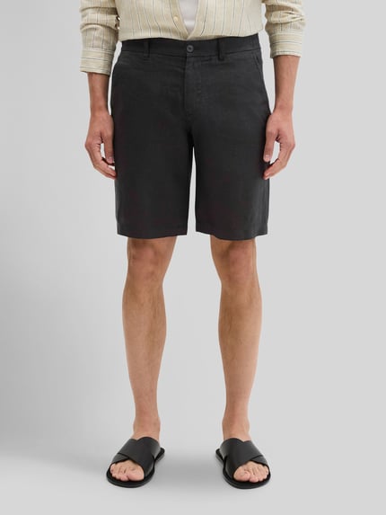 Mężczyzna nosi Regular Fit Shorts aus reinem Leinen Modell 'RESO JOGGER' von Marc O'Polo, czarne, jednolity wzór, len, krój regular fit, kieszenie boczne i z lamówką, zapięcie na guzik oraz kryty zamek, Ganzkörperansicht von vorne.