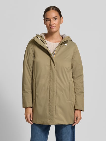 Frauenmodel trägt Regular Fit Mantel mit Logo-Applikation Modell 'SOPHIE' von K-WAY, sandfarben, Kapuze, glatte Textur, Ganzkörperansicht von vorne, Damenmantel Regular Fit, Rückenlänge 73 cm, Schulterbreite 41 cm, Brustweite 46 cm, Ärmellänge 53 cm.